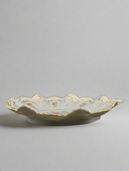Decorative ceramic plate with scalloped edge on a gray background